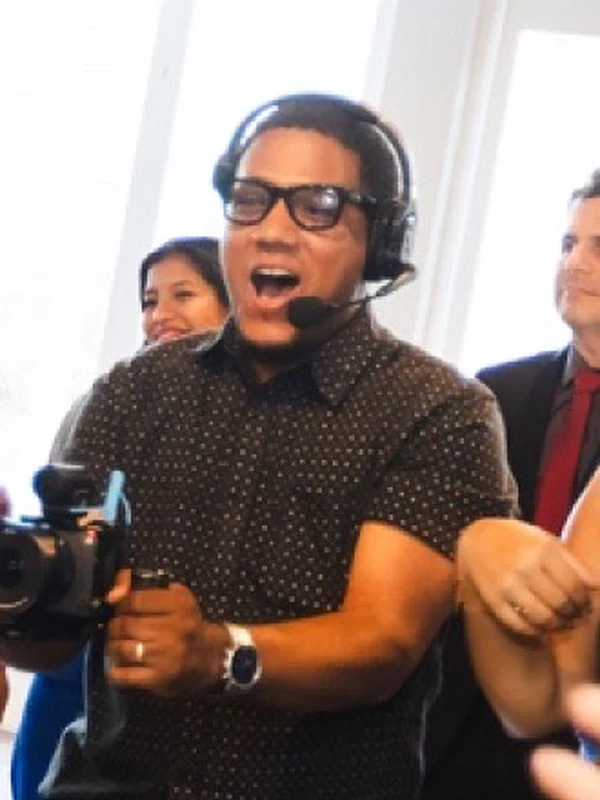 Justo Peña on headset with a camera during a wedding reception
