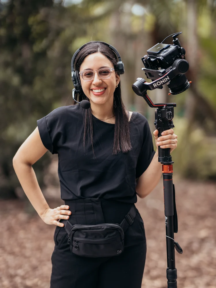 Maria Peña on set with a headset and a Ronin-mounted camera