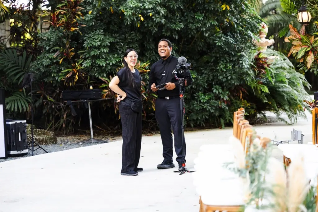 Justo and Maria Peña, Solfilms co-founders, laughing together between takes at an outdoor wedding venue