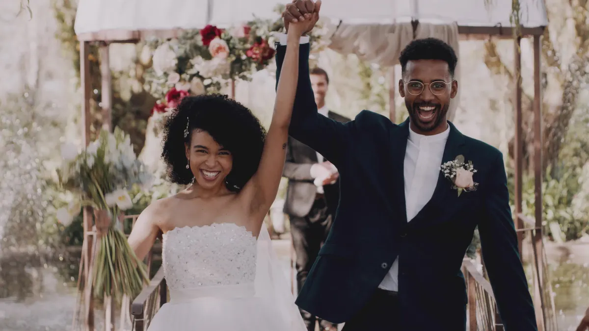 Outdoor wedding ceremony with guests and cinematographer capturing vows from the aisle